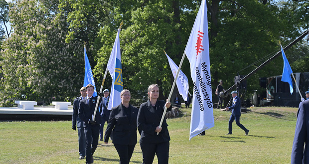 Ett led av människor som bär på flaggor.