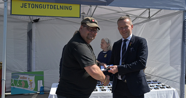 En man tar emot minnesjetong av en man i kostym.