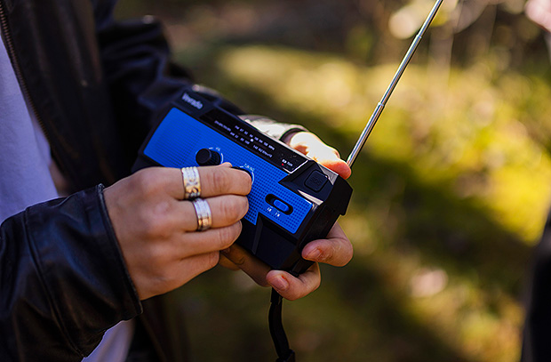 En person håller i en batteridriven radio.