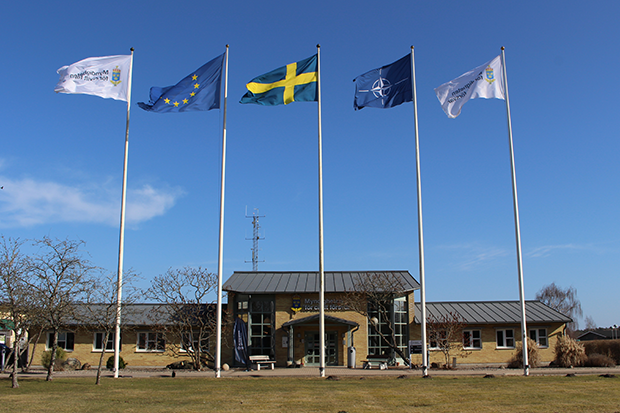 Entrén till skolan i Revinge med flaggstänger framför. 