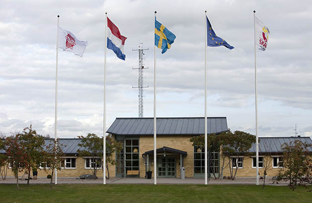 Entrén till skolan i Revinge med flaggstänger framför. 