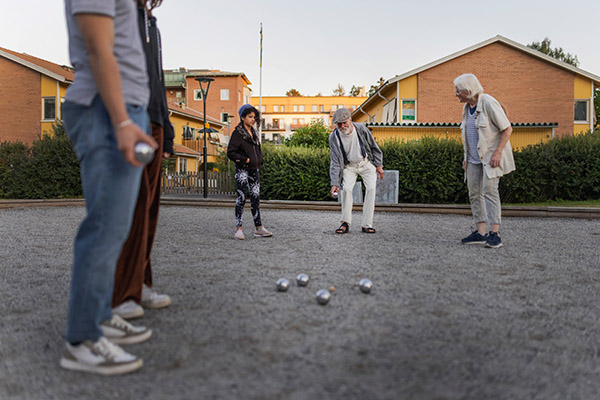 Flera personer på en grusplan som spelar boule