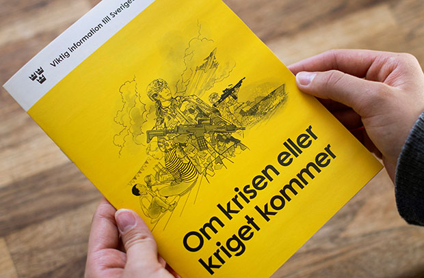 Hand håller broschyr.