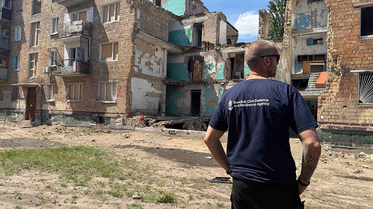 Person som står och kollar på en nedslagsplats i Ukraina.