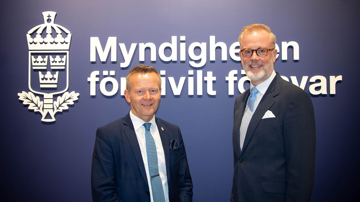 Mikael Frisell, generaldirektör Myndigheten för civilt försvar och Magnus Corell, generaldirektör Luftfartsverket står tillsammans framför blå vägg med Myndigheten för civilt försvars logotyp.