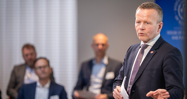 En man står och pratar inför människor. 