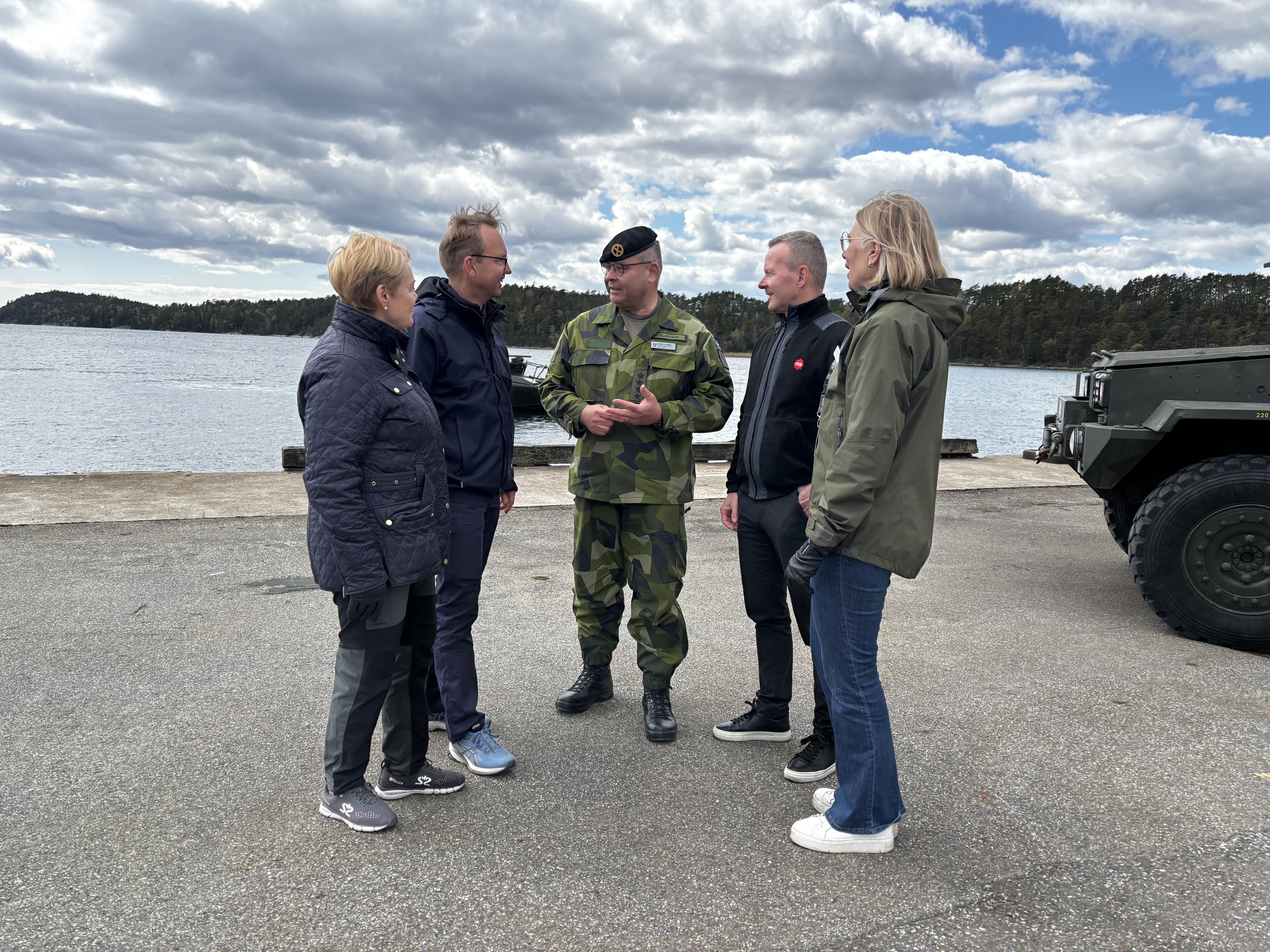 människor står i grupp framför vatten