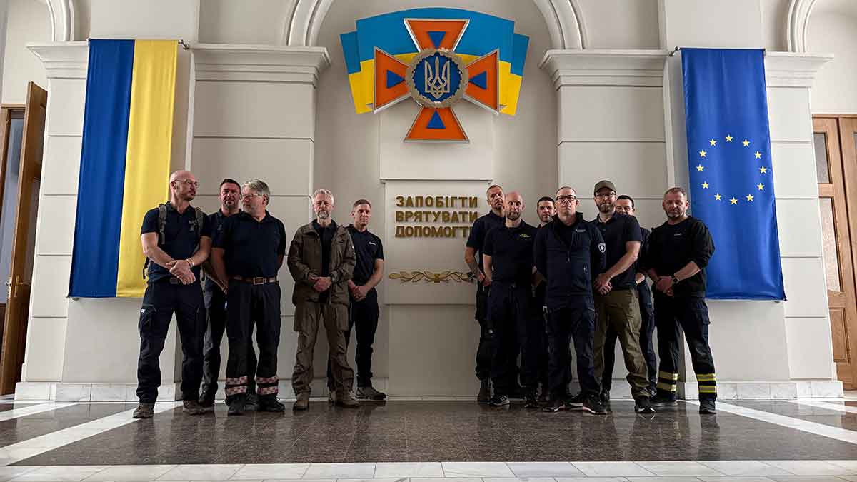 Gruppbild framför Ukrainas flagga.