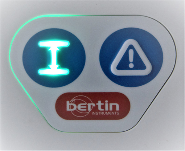 Display för extern mätprob för detektering av alfa (α) och beta (β) strålning. Två blå ringar en som visar höjden över mät objektet och är upplyst med grön färg samt en för varning som markeras med en triangel med ett utropstecken.